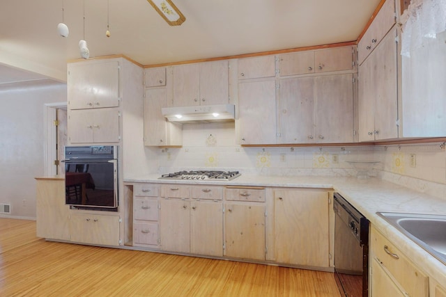 kitchen with black appliances, backsplash, light wood-type flooring, and light brown cabinets