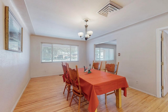 dining area featuring light hardwood / wood-style flooring and a chandelier