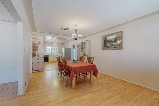 dining area featuring baseboards, light wood-style flooring, visible vents, and a notable chandelier