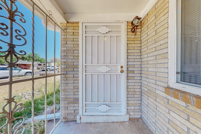 property entrance featuring brick siding