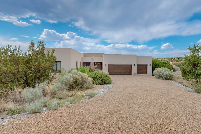 pueblo revival-style home with a garage