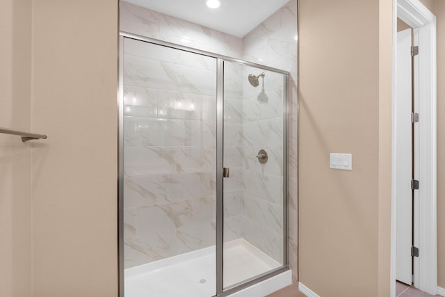 bathroom with a shower stall and baseboards