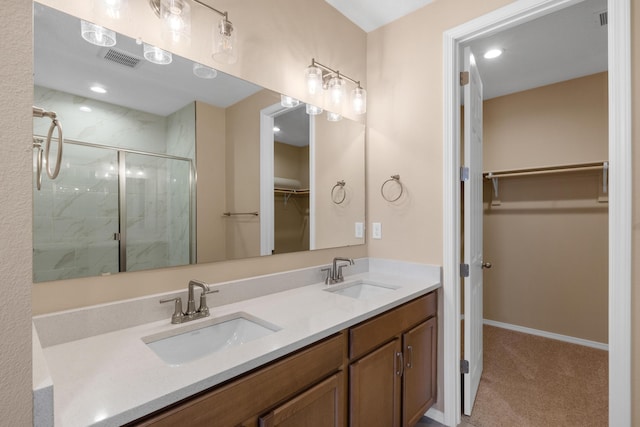 bathroom featuring double vanity, visible vents, a marble finish shower, and a sink