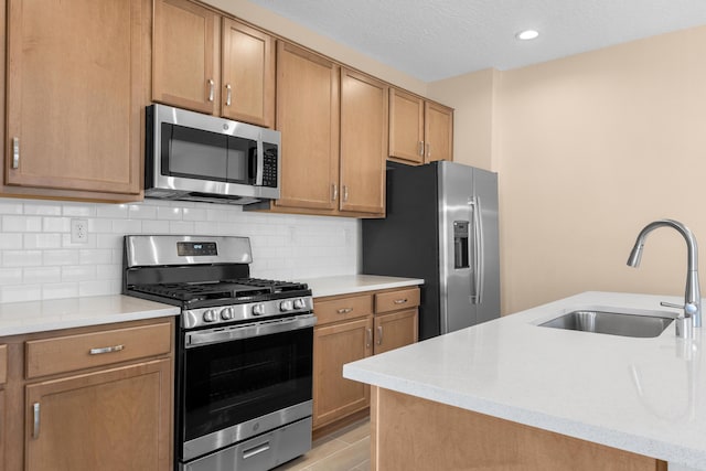 kitchen with a sink, a textured ceiling, stainless steel appliances, light countertops, and decorative backsplash