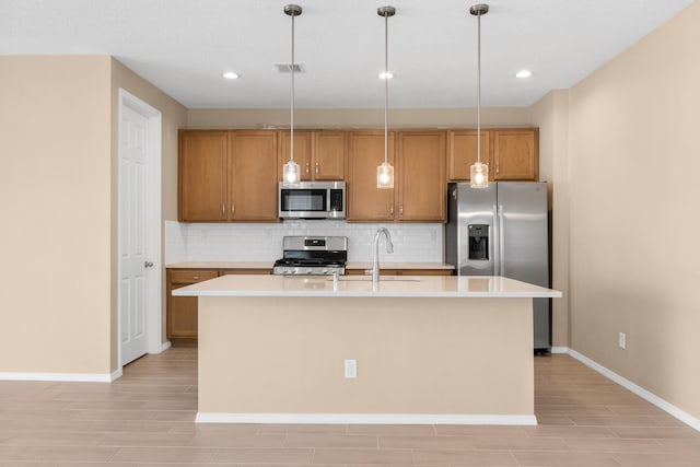 kitchen featuring visible vents, a sink, light countertops, appliances with stainless steel finishes, and tasteful backsplash