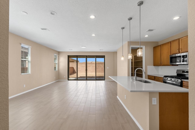 1334 Vallecito Ct NW, Los Lunas, NM 87031 - kitchen with backsplash, open floor plan, appliances with stainless steel finishes, brown cabinetry, and a sink