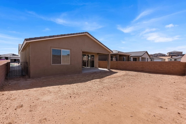 back of house with a fenced backyard and stucco siding