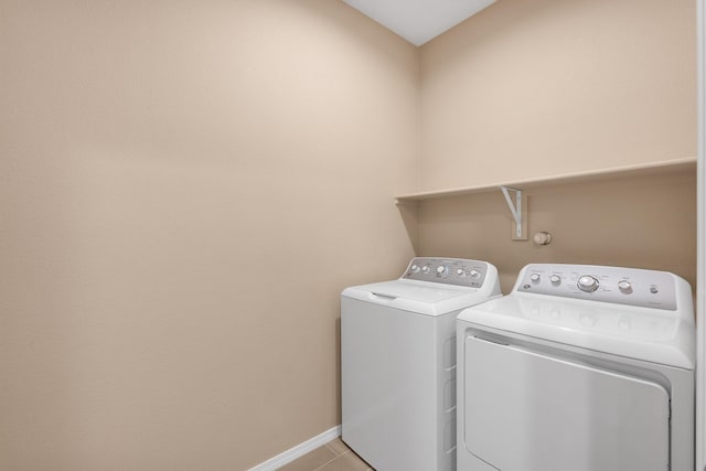 laundry room with laundry area, light tile patterned flooring, baseboards, and washing machine and clothes dryer