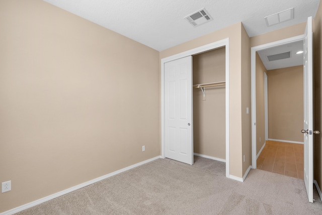 unfurnished bedroom featuring a closet, visible vents, baseboards, and carpet