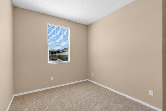 unfurnished room featuring baseboards, carpet floors, and a textured ceiling