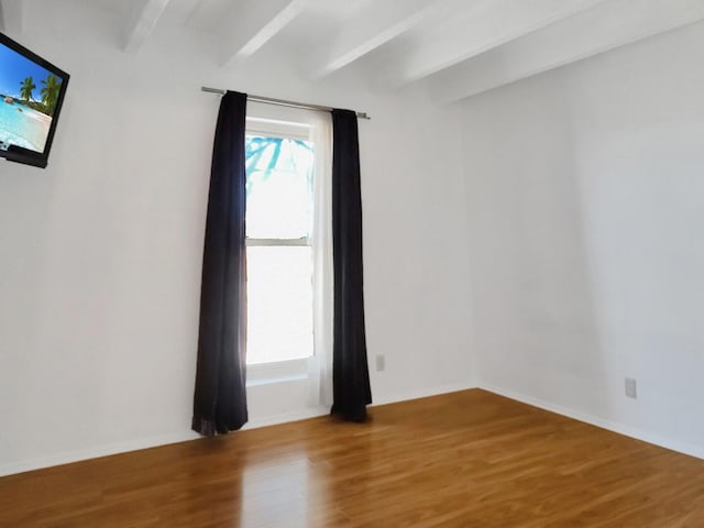 unfurnished room with hardwood / wood-style flooring and beam ceiling