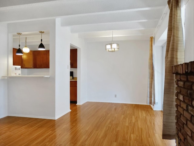 unfurnished living room featuring beamed ceiling, an inviting chandelier, and light hardwood / wood-style flooring