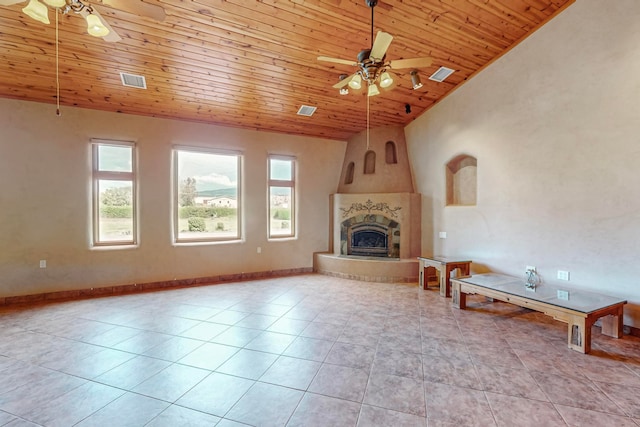 unfurnished living room with wooden ceiling, ceiling fan, light tile patterned floors, and a large fireplace