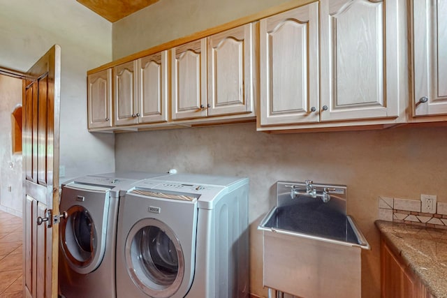 laundry room with cabinets, washing machine and clothes dryer, and light tile patterned flooring