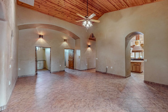 unfurnished living room with wooden ceiling, light tile patterned flooring, ceiling fan, and high vaulted ceiling