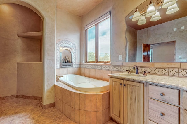 bathroom featuring tile patterned flooring, vanity, and a relaxing tiled tub