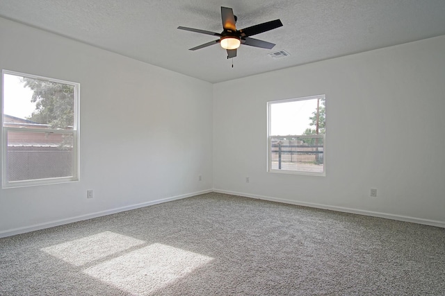 carpeted spare room featuring ceiling fan and a textured ceiling