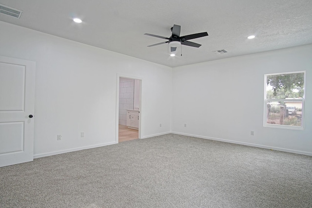 spare room featuring ceiling fan, carpet floors, and a textured ceiling