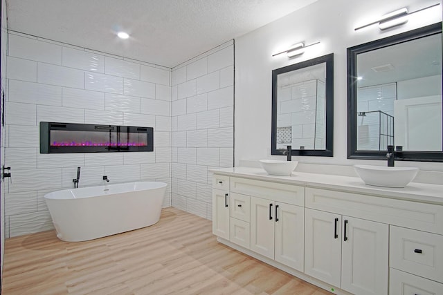 bathroom with separate shower and tub, tile walls, a textured ceiling, vanity, and hardwood / wood-style flooring