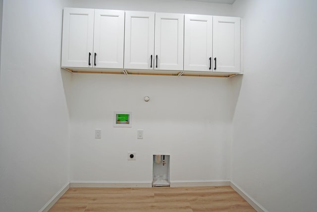 washroom with gas dryer hookup, electric dryer hookup, cabinets, washer hookup, and light wood-type flooring