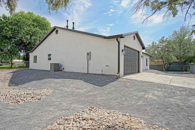 view of side of home featuring central AC unit and a garage