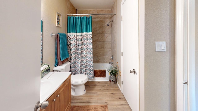 full bathroom with shower / bath combo with shower curtain, hardwood / wood-style floors, vanity, and toilet