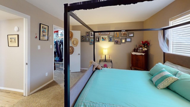 bedroom featuring a spacious closet, a closet, and hardwood / wood-style flooring