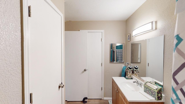 bathroom with hardwood / wood-style floors and vanity