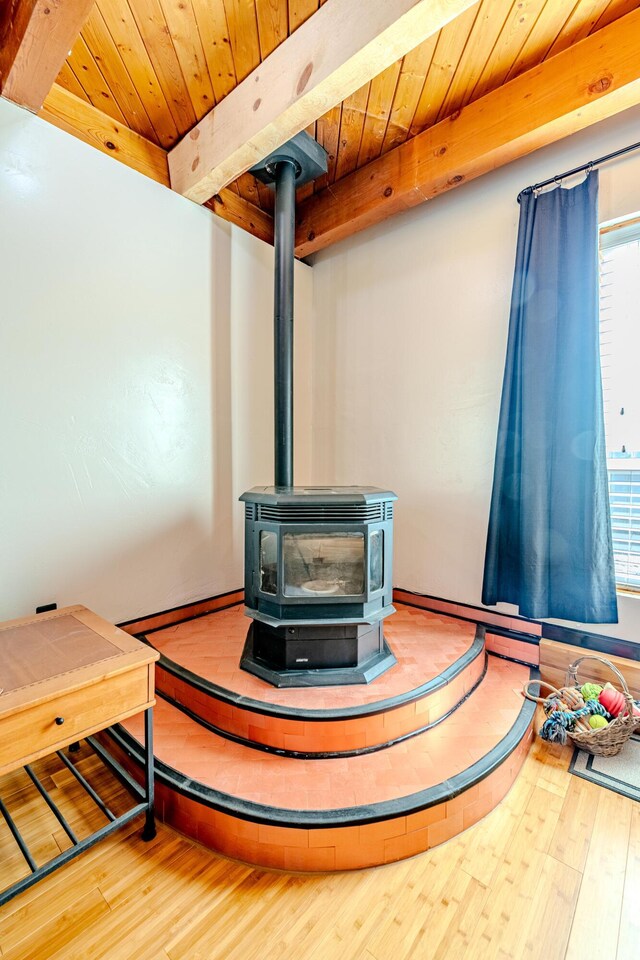 interior details featuring hardwood / wood-style flooring, a wood stove, and wood ceiling