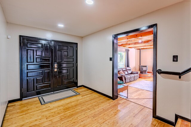 foyer with beam ceiling and light hardwood / wood-style floors