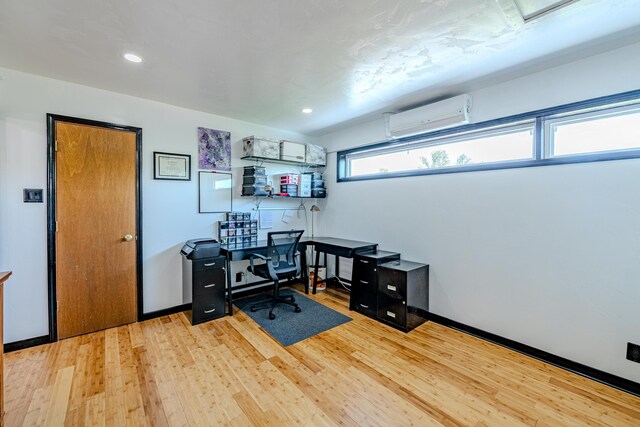 office space featuring light wood-type flooring and a wall mounted AC