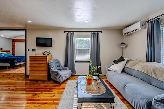 living room featuring a wall mounted air conditioner and wood-type flooring