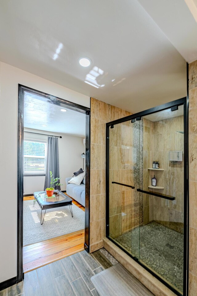 bathroom with an enclosed shower and hardwood / wood-style flooring