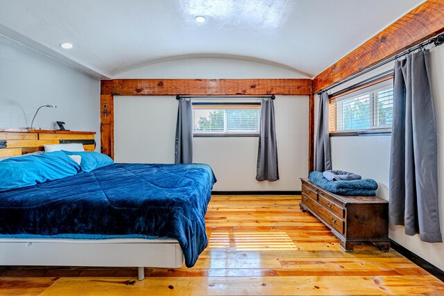 bedroom with light hardwood / wood-style floors, lofted ceiling, and multiple windows