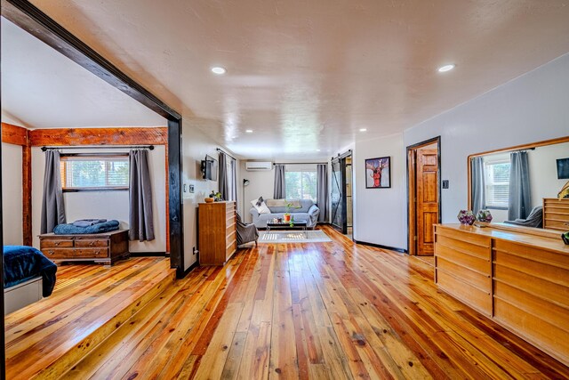 living room with a wall mounted AC and hardwood / wood-style floors