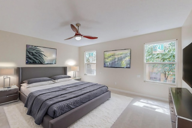 carpeted bedroom with ceiling fan and multiple windows