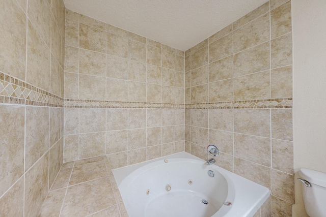 bathroom with toilet, a textured ceiling, tiled bath, and tile walls