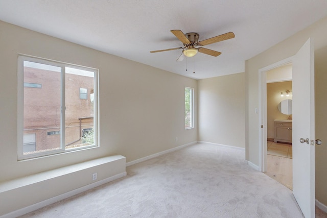 spare room with ceiling fan and light colored carpet