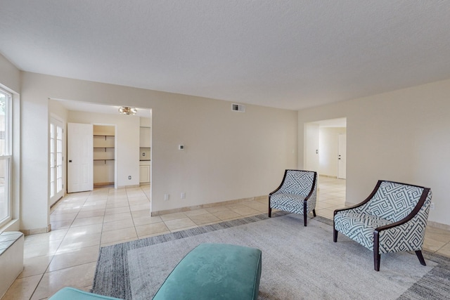 living area featuring light tile patterned floors and a textured ceiling