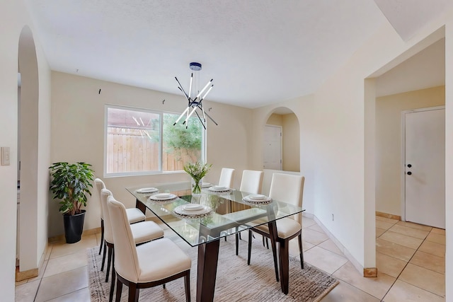 dining space featuring light tile patterned floors and an inviting chandelier