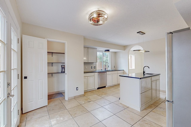 kitchen with ceiling fan, sink, decorative light fixtures, light tile patterned floors, and appliances with stainless steel finishes