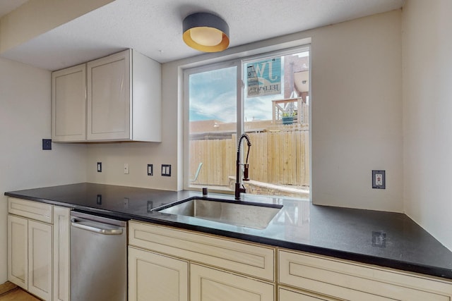 kitchen with cream cabinets, a textured ceiling, and sink