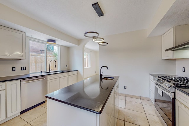 kitchen featuring pendant lighting, black gas stove, sink, stainless steel dishwasher, and an island with sink