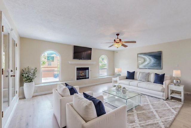 living room with ceiling fan and light hardwood / wood-style flooring