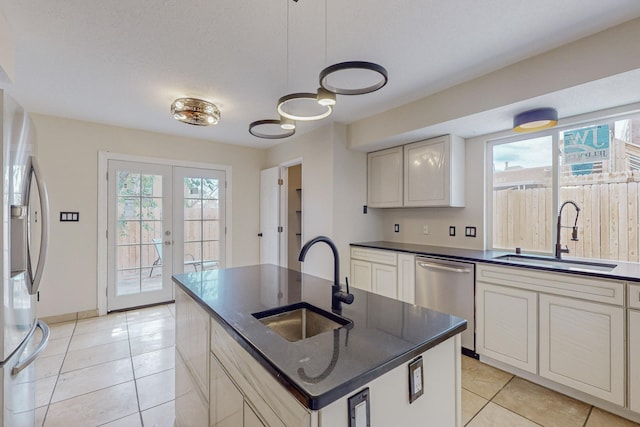 kitchen with french doors, sink, a center island with sink, and appliances with stainless steel finishes