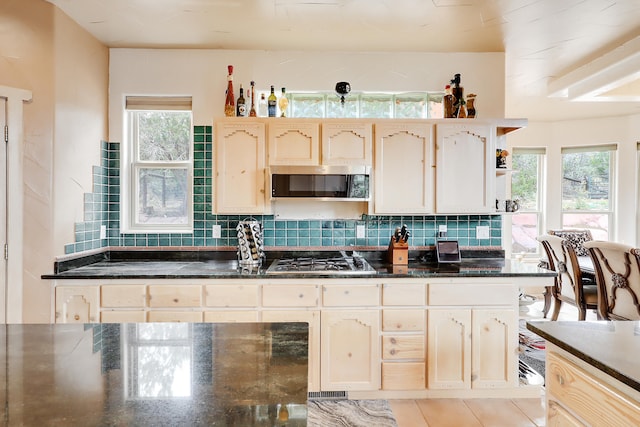 kitchen featuring backsplash, appliances with stainless steel finishes, and light tile patterned floors