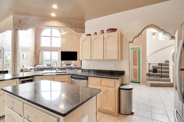 kitchen with sink, kitchen peninsula, stainless steel appliances, light tile patterned floors, and ceiling fan