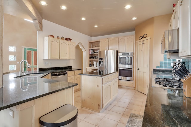 kitchen with kitchen peninsula, light tile patterned floors, stainless steel appliances, a center island, and sink