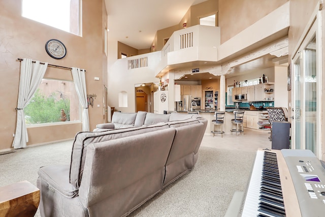 living room featuring light colored carpet and a towering ceiling