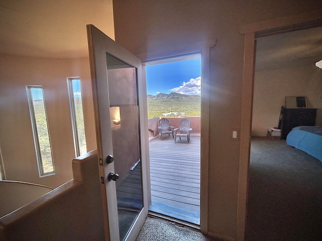 doorway to outside featuring carpet, a wealth of natural light, and a mountain view